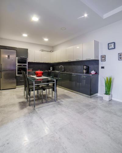 a kitchen with a table and chairs and a refrigerator at Epirus Hotel in Sarandë