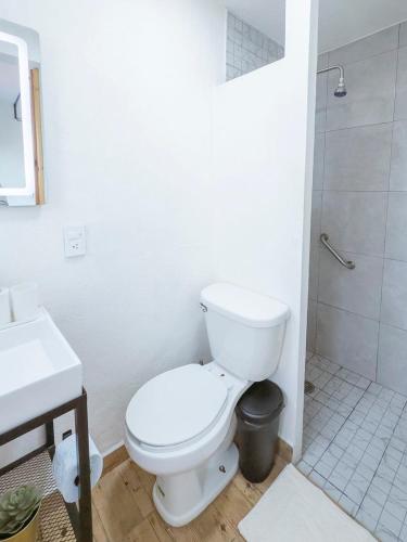 a white bathroom with a toilet and a sink at Comfortable Retreat in Cocoyoc Pool & BBQ in Cocoyoc