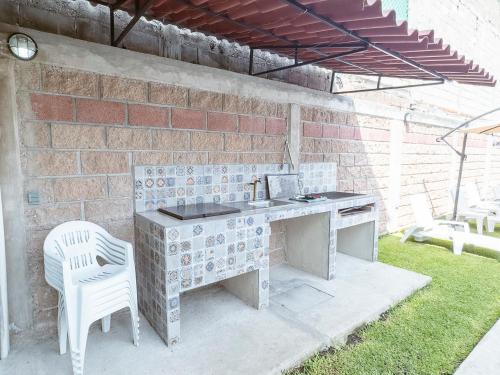a outdoor kitchen with a sink and a chair at Comfortable Retreat in Cocoyoc Pool & BBQ in Cocoyoc