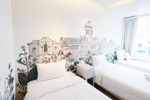 a bedroom with two beds and a mural of a building at Beat Hotel Bangkok in Bangkok