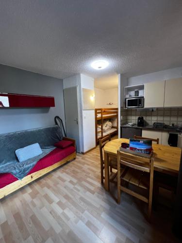 Cette chambre comprend un lit, une table et une cuisine. dans l'établissement Studio au cœur de la station de Risoul 1850, à Risoul