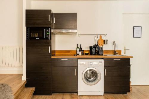 une cuisine avec une machine à laver dans une cuisine dans l'établissement Suite Les Nébuleuses, Terreaux Capucins, à Lyon