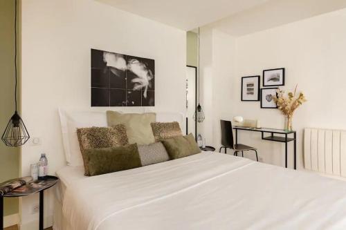 a white bedroom with a large white bed with pillows at Suite Les Nébuleuses, Terreaux Capucins in Lyon