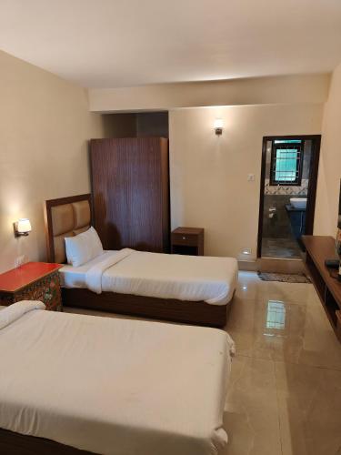Postel nebo postele na pokoji v ubytování Yangkhyil Residency