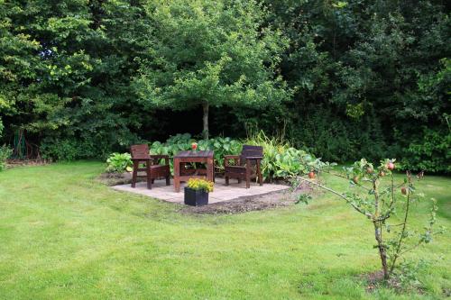 a table and two chairs in a garden at Den gamle stald in Ovtrup