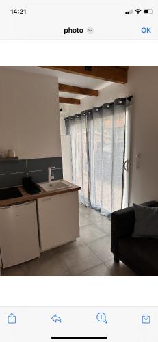 une cuisine avec un évier et un canapé dans une chambre dans l'établissement Studio calme avec jardin et parking privé, à La Ciotat