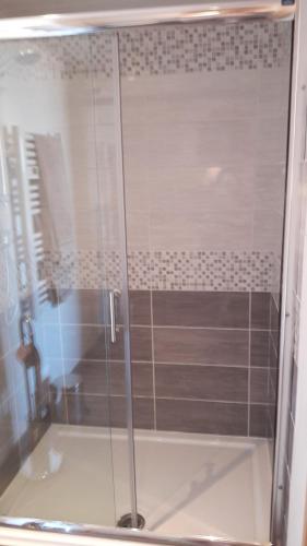 une douche avec une porte vitrée dans une salle de bain dans l'établissement chambre à la campagne au milieu des lavandes, à Valensole