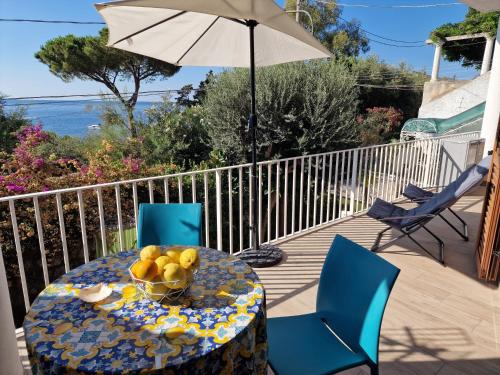 a table with a bowl of fruit on a balcony at Siren Land - Marina del Cantone in Nerano