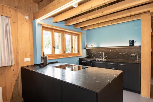 a kitchen with a black counter top and a sink at Chalet Meiseli in Adelboden