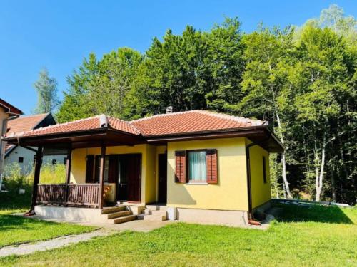 a small yellow house with a red roof at Vila Krunica in Šerdanova Mahala
