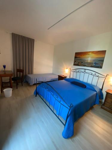 a bedroom with a blue bed and a table at AGRITURISMO LE GHIRLANDE in Valeggio sul Mincio