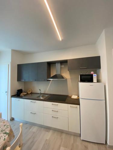 a kitchen with white cabinets and a white refrigerator at AGRITURISMO LE GHIRLANDE in Valeggio sul Mincio