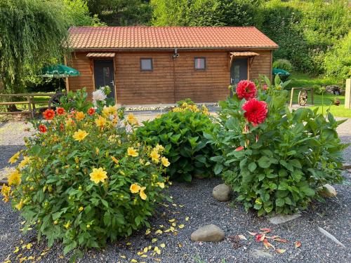 a garden with flowers in front of a house at Auberge Restaurant La Roseraie in Grandrupt