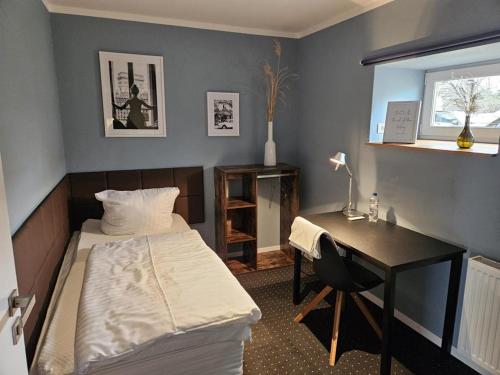 a room with a bed and a desk and a bed and a window at Pension Flughafen Leipzig in Freiroda