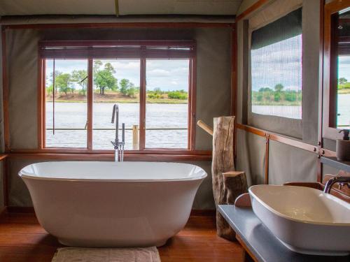 a bathroom with a large tub and a sink at Ndhovu Safari Lodge in Mahango