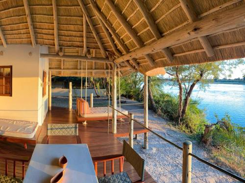 a porch of a house with a view of the water at Ndhovu Safari Lodge in Mahango