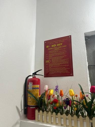 a fire hydrant and flowers on a shelf with a sign at Sapa Harmony Homestay in Sapa