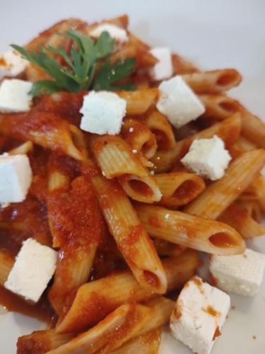 a plate of pasta with cheese and a garnishment at Station 44 Apartments in Bitola
