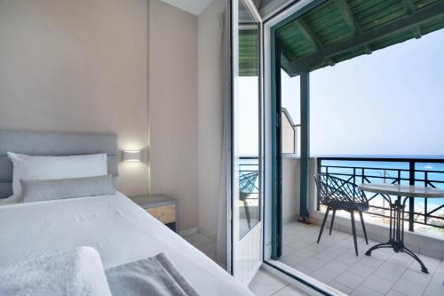 una camera da letto con un letto e un balcone con un tavolo di Sunset Triple 1 a Ayios Nikitas