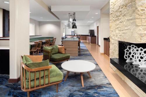 a lobby with a fireplace and chairs and a table at Fairfield Inn Fort Leonard Wood St. Robert in Saint Robert