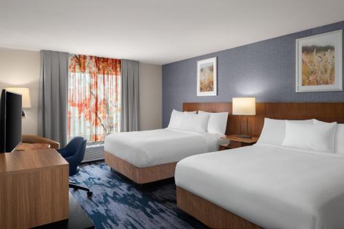a hotel room with two beds and a television at Fairfield Inn Fort Leonard Wood St. Robert in Saint Robert