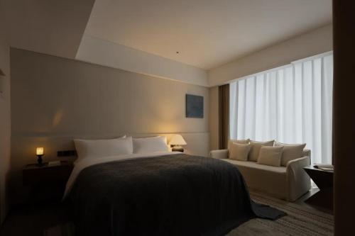 a hotel room with a bed and a couch at Phoenix Hall House Hotel in Fenghuang