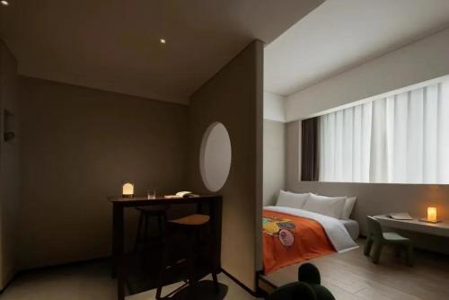 a bedroom with a bed and a table and a window at Phoenix Hall House Hotel in Fenghuang