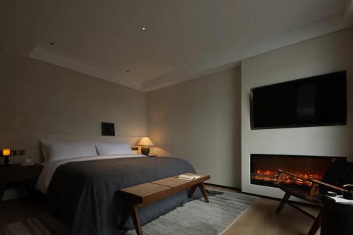 a bedroom with a bed and a fireplace and a tv at Phoenix Hall House Hotel in Fenghuang