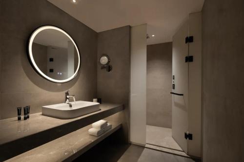 a bathroom with a sink and a mirror at Phoenix Hall House Hotel in Fenghuang