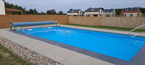 a swimming pool in a backyard with a fence at Garden Baltic in Trzęsacz