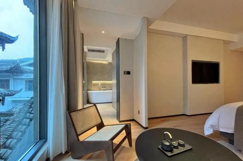 a hotel room with a bed and a large window at Phoenix Hall House Hotel in Fenghuang