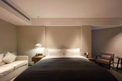 a bedroom with a large bed and a couch at Phoenix Hall House Hotel in Fenghuang