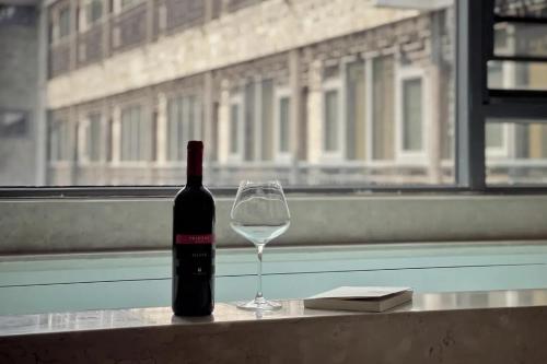 a bottle of wine and a glass on a table at Phoenix Hall House Hotel in Fenghuang