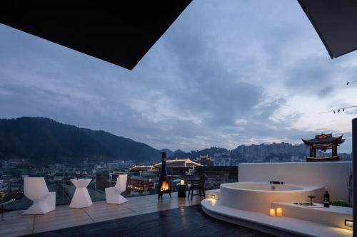 a building with white furniture and a view of a city at Phoenix Hall House Hotel in Fenghuang