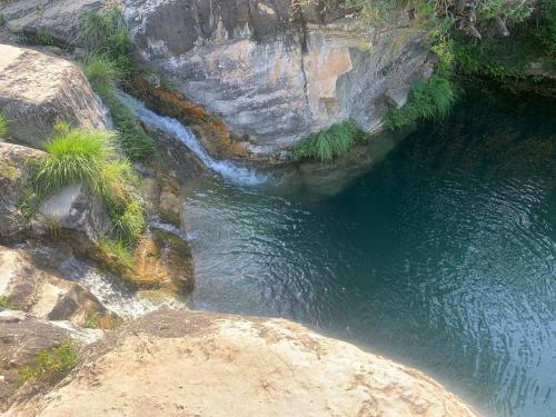 an aerial view of a river with rocks and waterfalls at Hostal Restaurante de Montaña Pous de la neu in Alfara de Carles