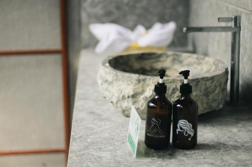 two bottles sitting on a counter next to a sink at Bhalance Retreat in Padangbai