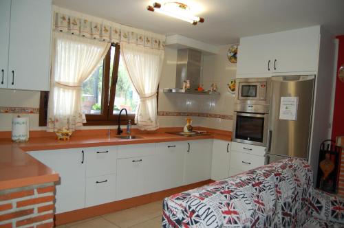 a kitchen with white cabinets and a counter top at Casa el patio in Ampuero