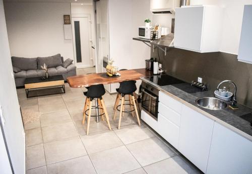 une cuisine avec une table et des tabourets dans une pièce dans l'établissement Appartement Marseille, à Marseille