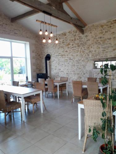 une salle à manger avec des tables et des chaises et un mur en briques dans l'établissement Ô calme, à Brizambourg