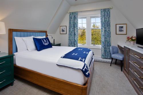 a bedroom with a bed and a desk and a television at The Inn at Stonecliffe in Mackinac Island
