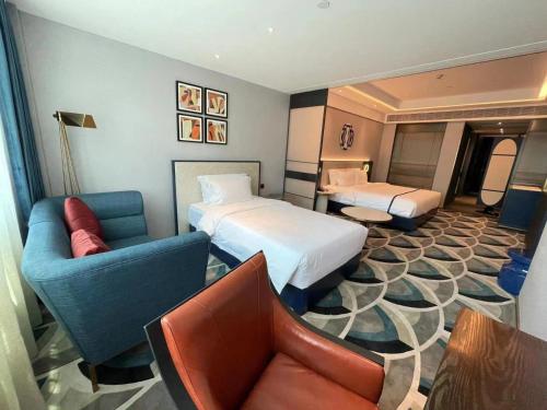 a hotel room with two beds and a couch at 西安钟楼枫渡酒店永兴坊地铁站店 in Xi'an