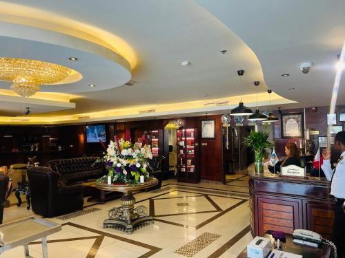 a lobby of a hotel with a table with flowers at Tourist Hotel in Doha