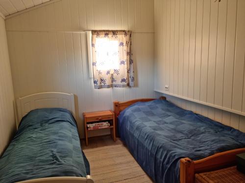 a bedroom with two beds and a window at Flott feriehus Søgne in Kristiansand