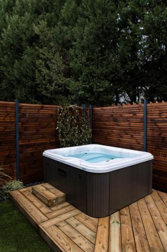 a hot tub sitting on top of a wooden deck at Logis Hôtel Domaine du Moulin Cavier - Restaurants & Spa in Avrillé