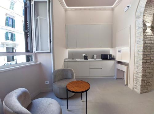 Una cocina con dos sillas y una mesa en una habitación. en Astom Suites, en Roma