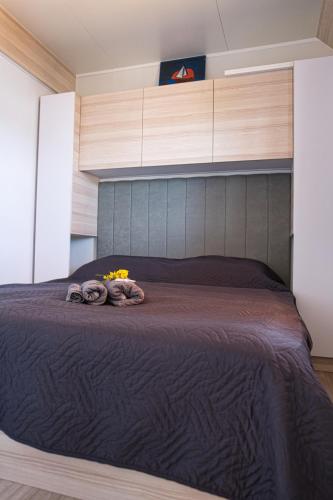 a bedroom with a large bed with a wooden headboard at Mobilehome Palema 16 in Drage