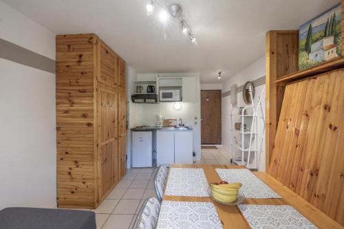 Il comprend une cuisine avec des murs en bois et une table. dans l'établissement Le hameau des Neiges, à Morillon