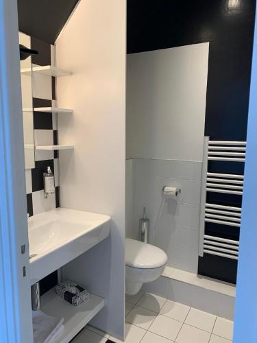 a bathroom with a white sink and a toilet at Logis Hôtel Domaine du Moulin Cavier - Restaurants & Spa in Avrillé