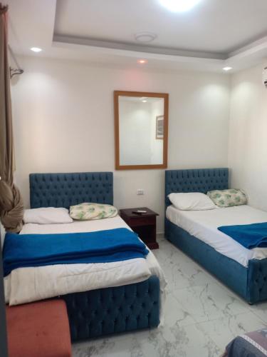 a bedroom with two beds and a mirror at A two-room chalet in the village of Lale Land, Mirage Bay, Ecopark in Hurghada