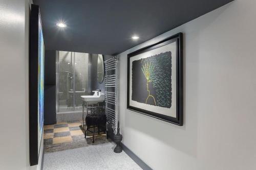 une salle de bains avec une photo d'une plante sur le mur dans l'établissement Le Secret, climatisé, Place des Terreaux-Lyon 1er, à Lyon